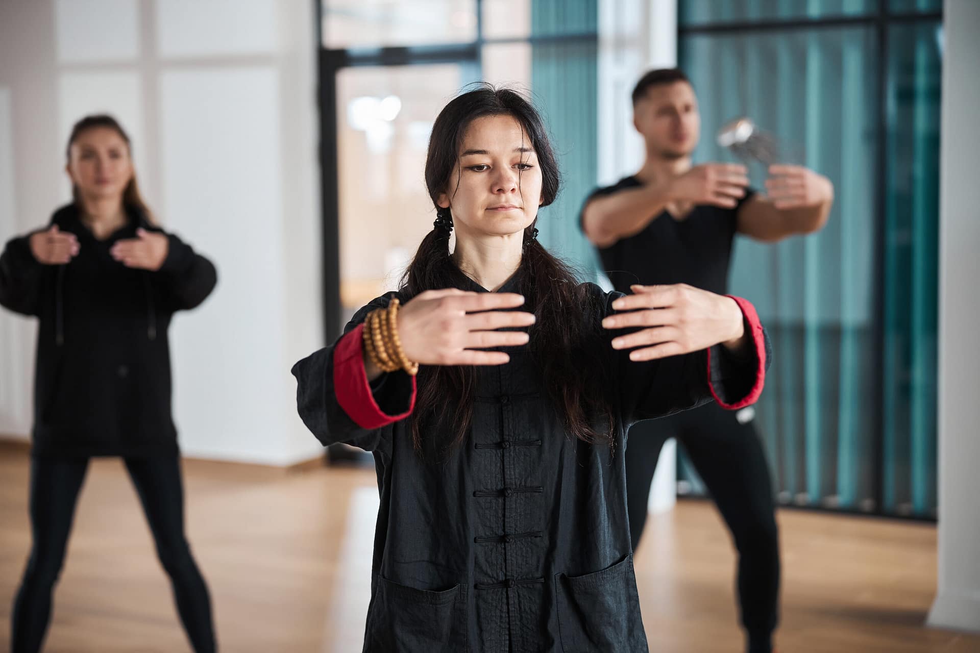 Composed qigong coach doing embrace gesture with arms
