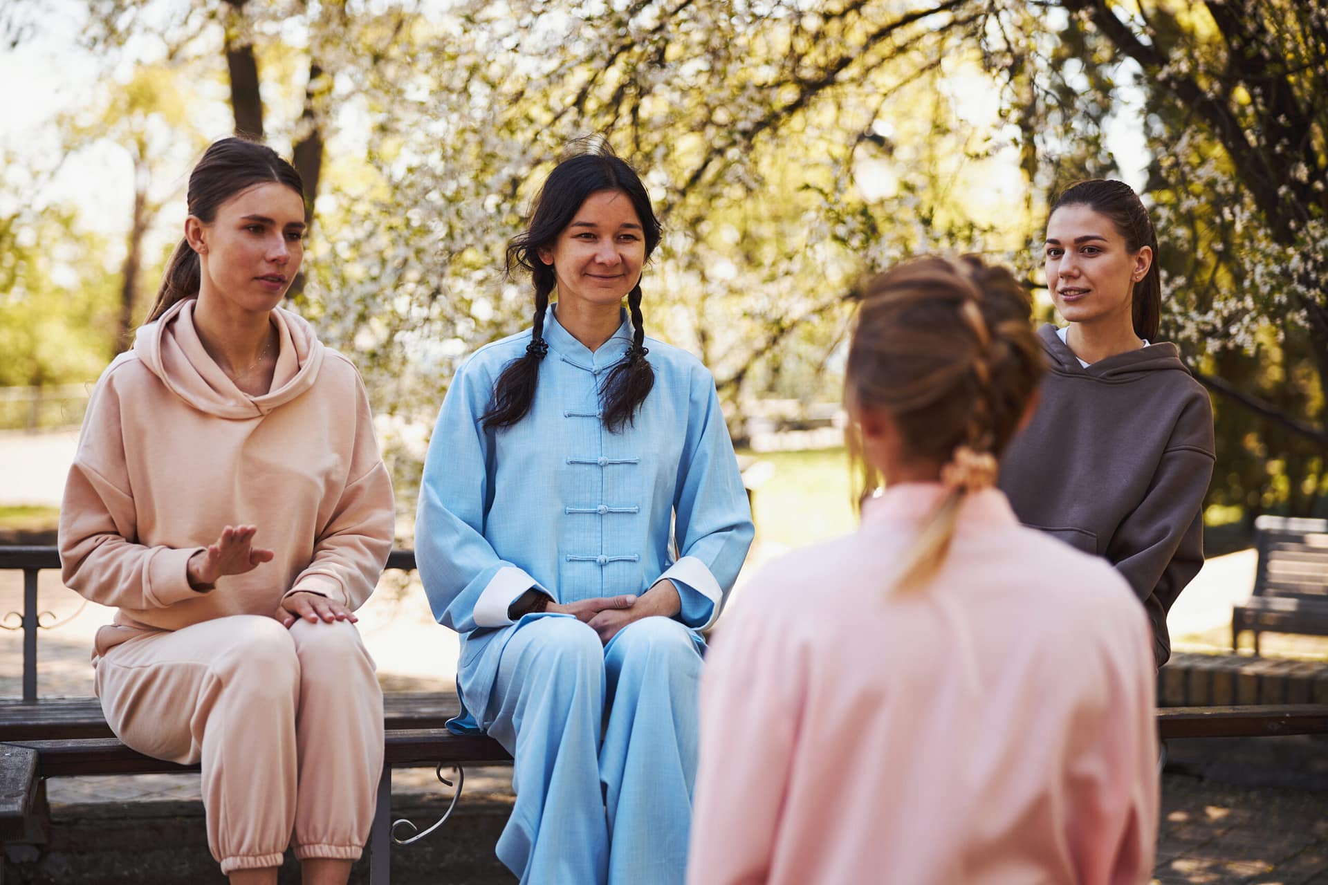 Positive Asian wushu master listening to her pupils